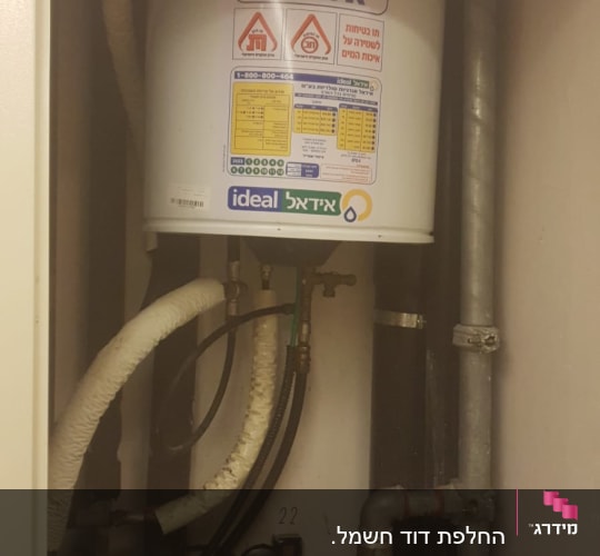 דוד שמש עם צינורות ומד לחץ בחדר שירות